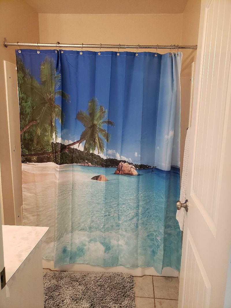 Neat and clean shower with a lovely beachy theme.