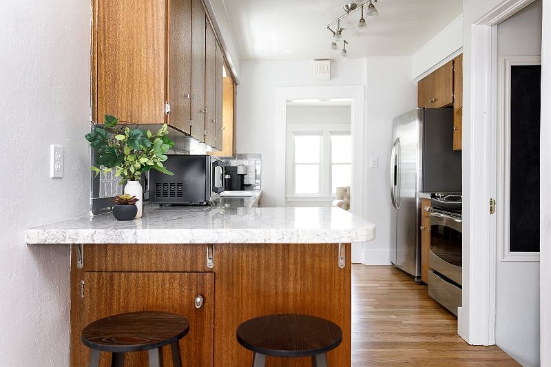 Fully-stocked kitchen with stone counters and stainless steel appliances