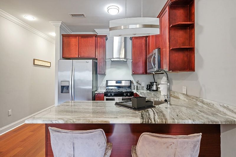 This airy, open-concept kitchen combines sleek design with everyday functionality, showcasing elegant finishes, ample counter space, and warm natural light. It's the perfect blend of style and practicality, ideal for both cooking and connection.