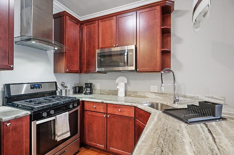 This airy, open-concept kitchen combines sleek design with everyday functionality, showcasing elegant finishes, ample counter space, and warm natural light. It's the perfect blend of style and practicality, ideal for both cooking and connection.