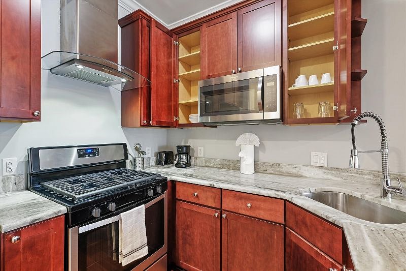 This airy, open-concept kitchen combines sleek design with everyday functionality, showcasing elegant finishes, ample counter space, and warm natural light. It's the perfect blend of style and practicality, ideal for both cooking and connection.