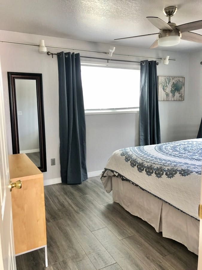 King bed on new pedestal with lower drawers. Full sized mirror. Room darkening drapes, and blinds.