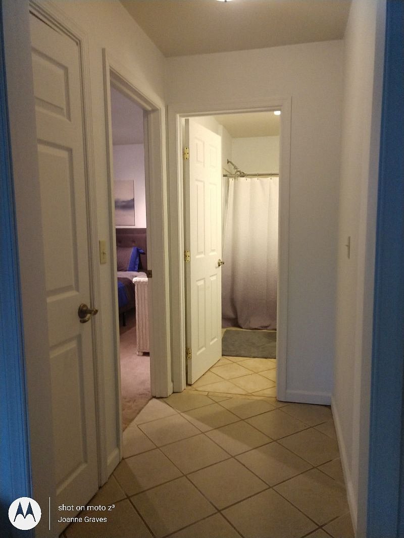 Hallway to closet, bed and bath with walk-in shower