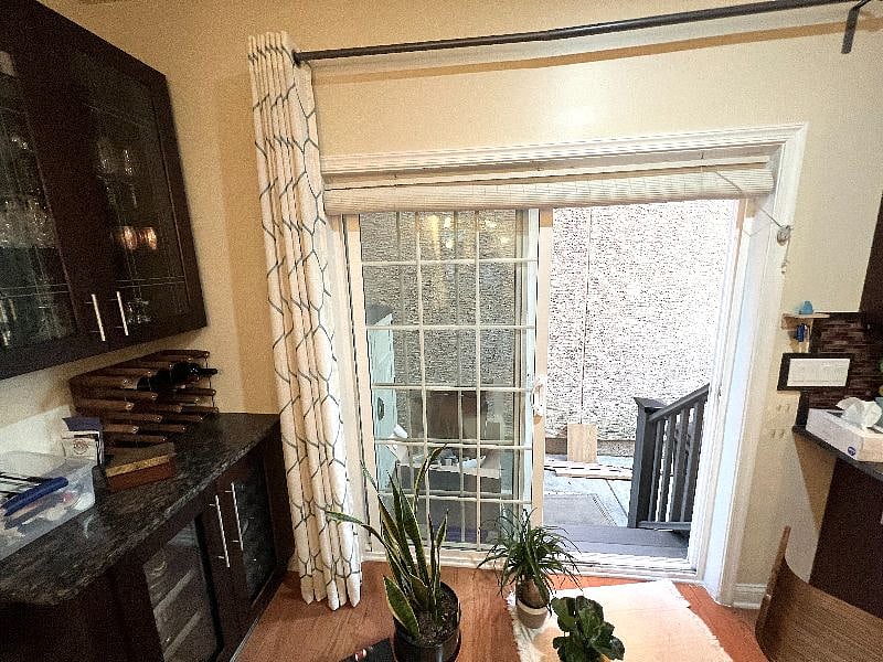 Custom installed bar area and glass cabinet; back slider door goes out to small patio with storage and locked back gate.