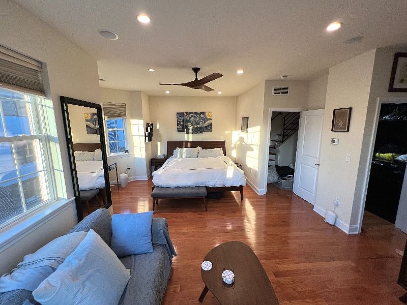 Main bedroom with king size bed, loveseat (also a pullout twin bed), mounted smart TV, and bay window with small desk. Dual walk in closets.