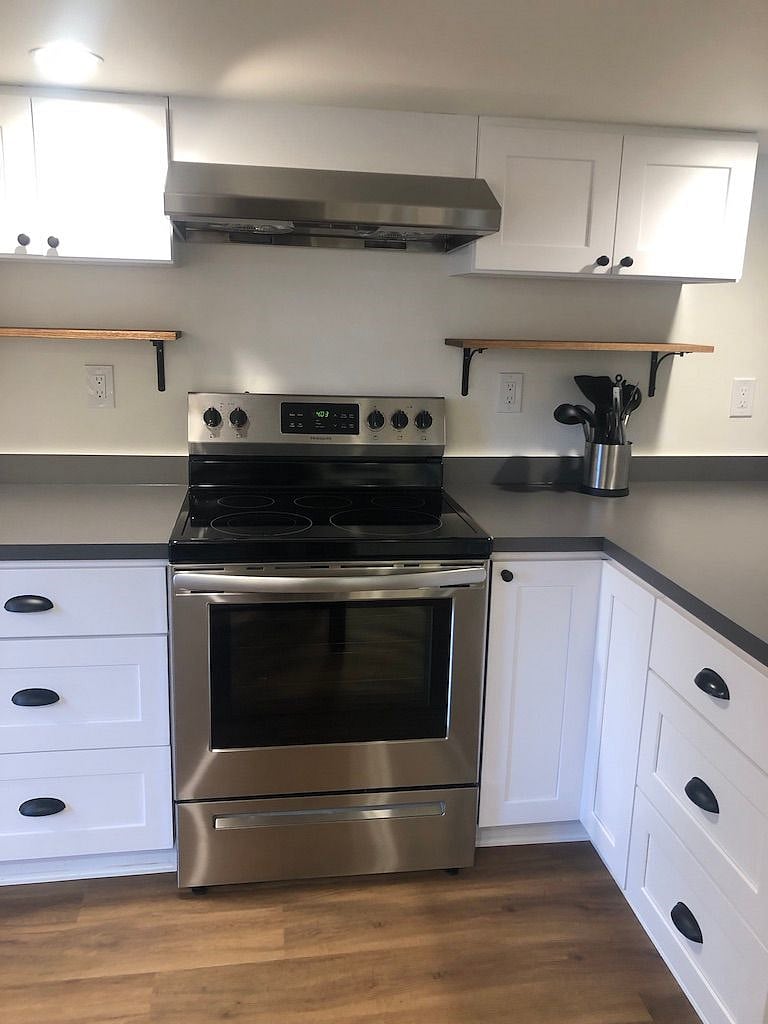 Kitchen has full sized oven and stove and is stocked with pots, pans, dishes and utensils.