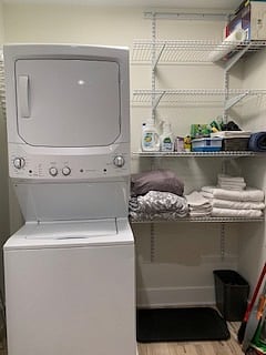 Full-size washer dryer in laundry room with shelves and doors