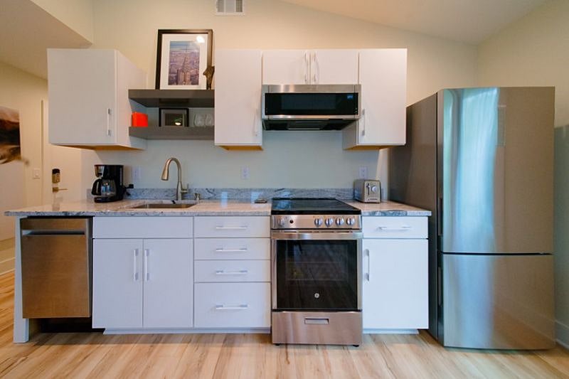 Full kitchen complete with stainless steel refrigerator, microwave, and dishwasher. Fully stocked with Keurig coffee maker, dishes, silverware, and pots and pans.
