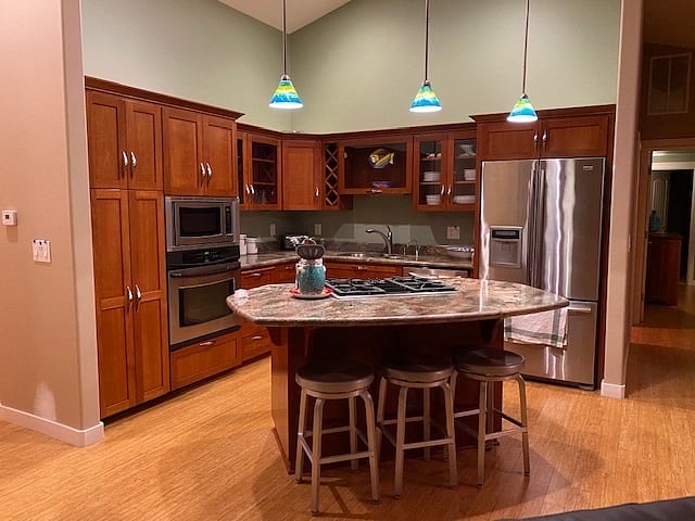 Kitchen with gas cooktop, microwave, dishwasher, wall oven, & fully stocked with kitchen accessories.