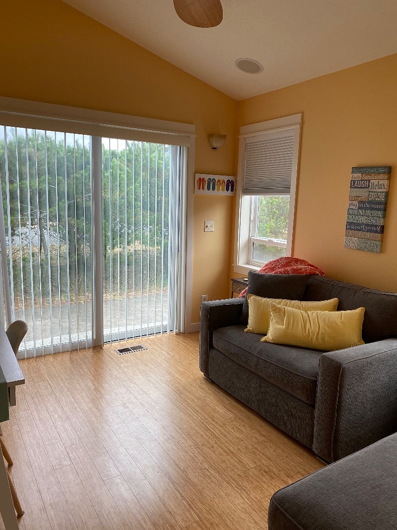 Office with convertible single sofa, desk, & smart tv.