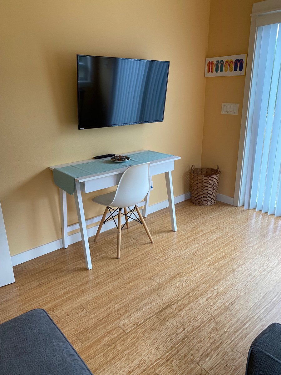 Office with desk, convertible single sofa, & smart tv.