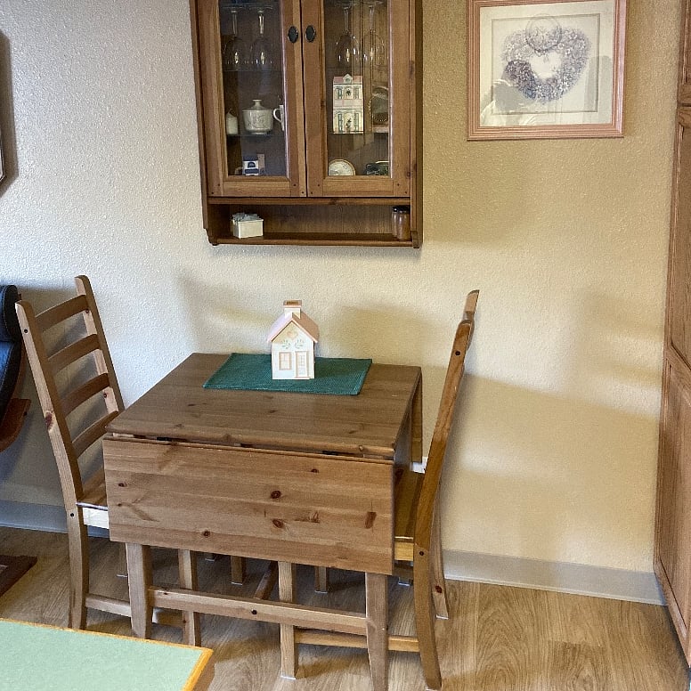 Dining table has leaves to extend the dining surface when entertaining. Overhead wall cabinet has extend serving items.