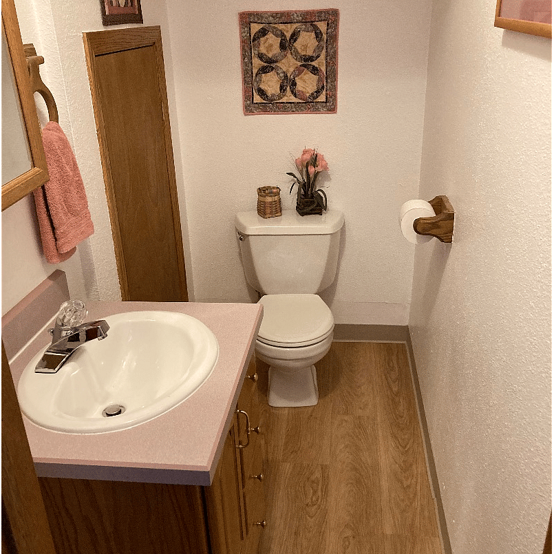 First floor bathroom and small hot water heater closet with snow shovel storage.
