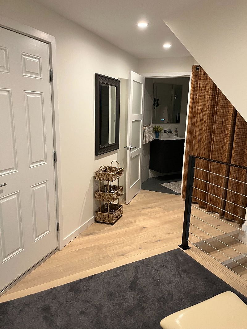 Center level Hallway to garage and stairs to entertainment room, lower level queen bedroom and backyard. 
