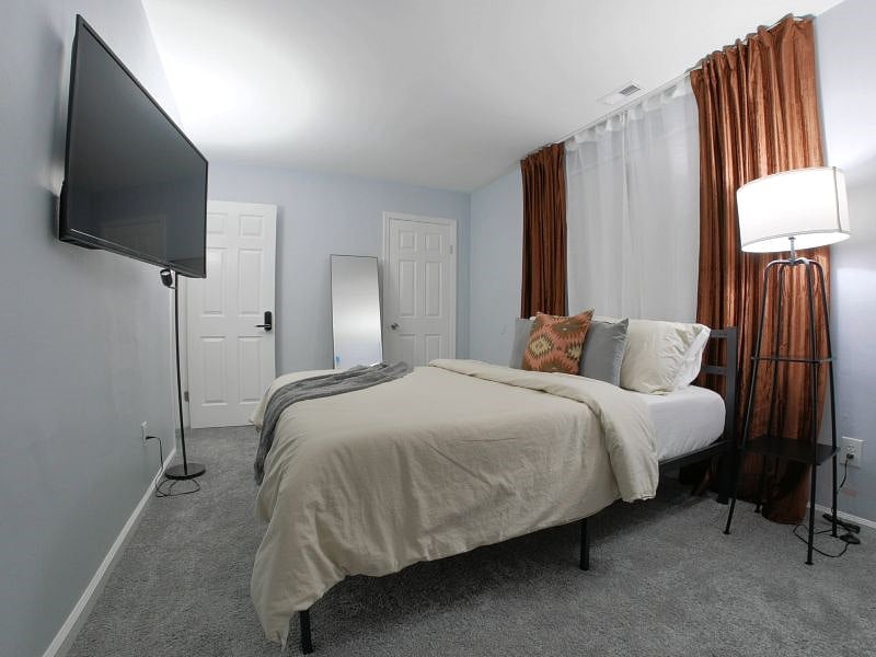 Bedroom 2. Features a 50" 4K LCD smart tv, full body mirror, and a chest of drawers with 3 large slide out drawers.