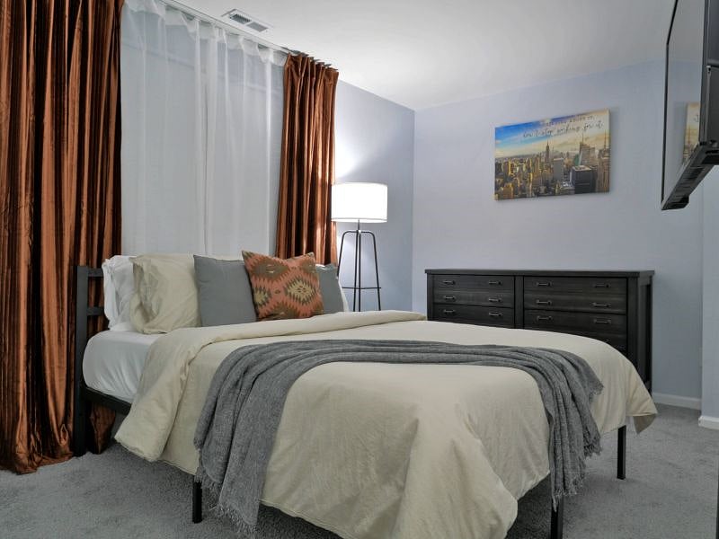 Bedroom 2. Queen size bed with a memory foam mattress. Black-out curtains provide a quiet and comfortable area for anyone needing to rest during day time hours.