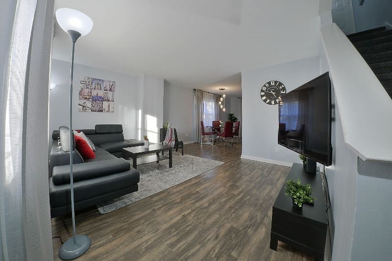 View of the living room and dining area from the front door. To the right are the stairs to the bedrooms upstairs.