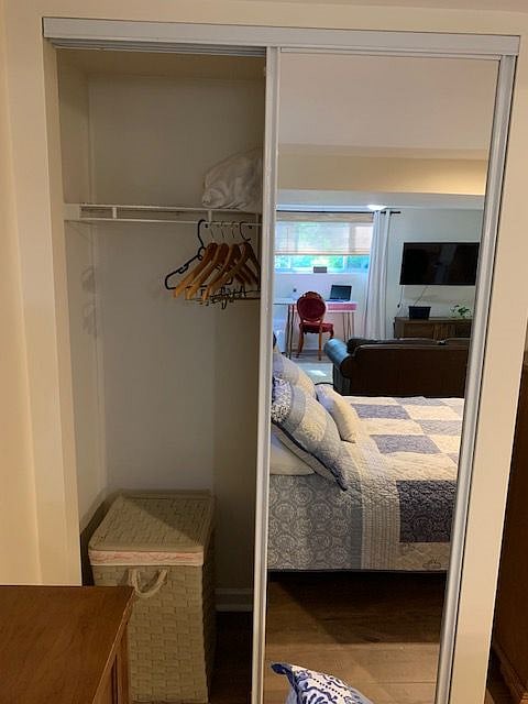 Closet with shelf and large, full-length mirror.