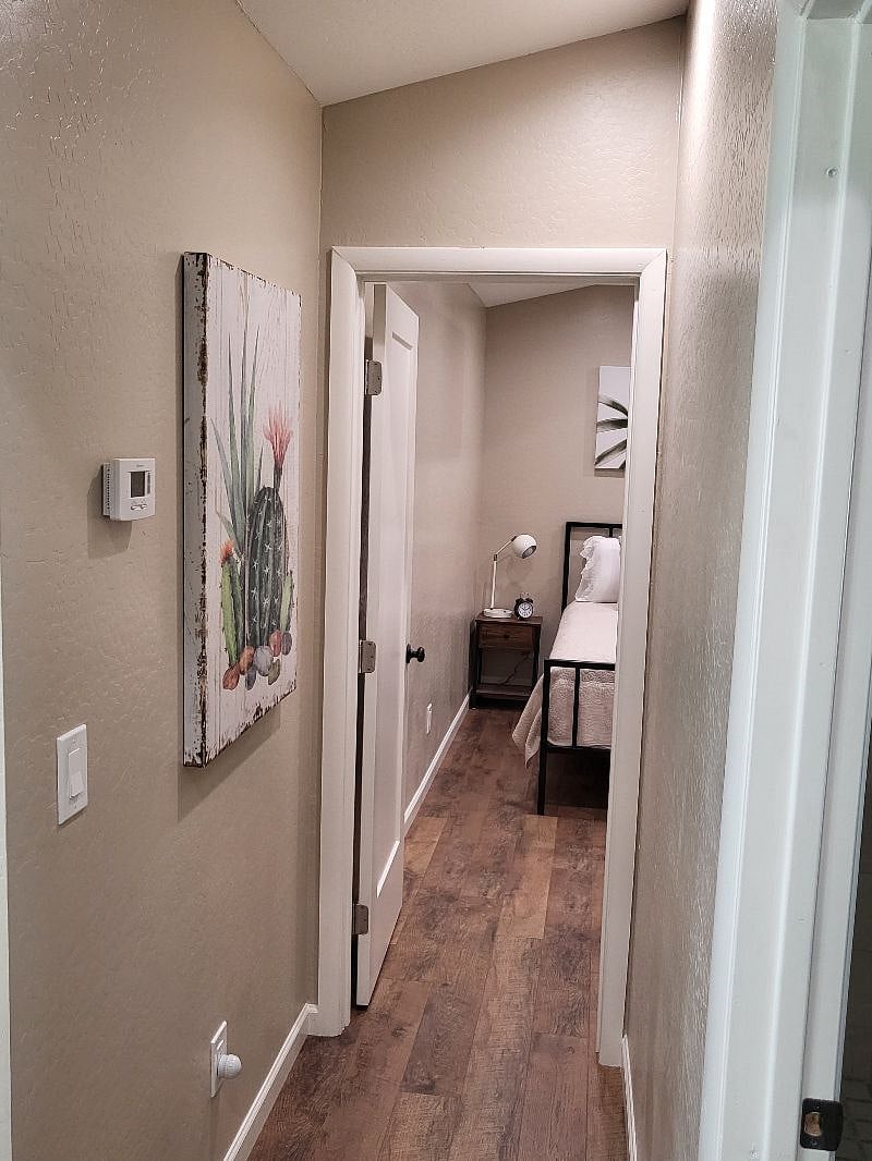 Hallway leads to the bedroom, ac thermostat. 