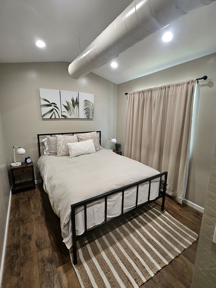 Queen bed with black out curtains, two end tables with lamps with usb charging