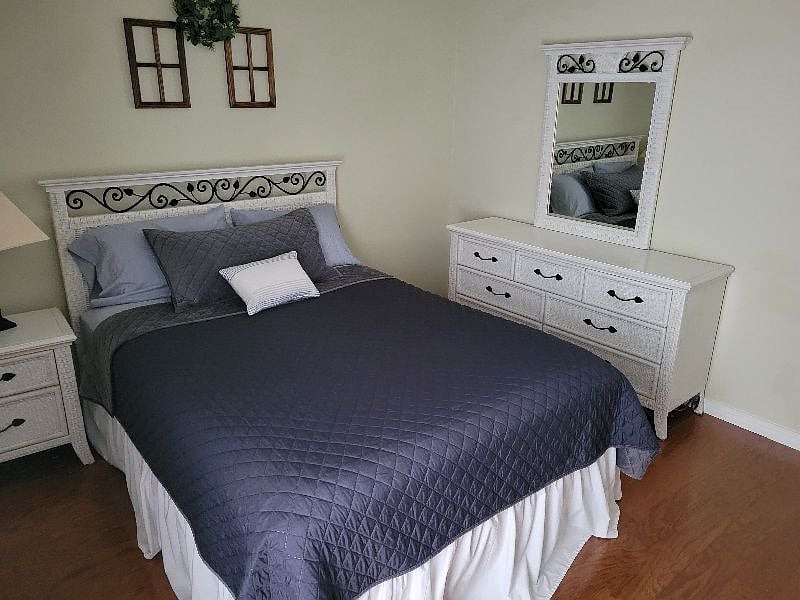Bedroom 2 with chest of drawers and end table.