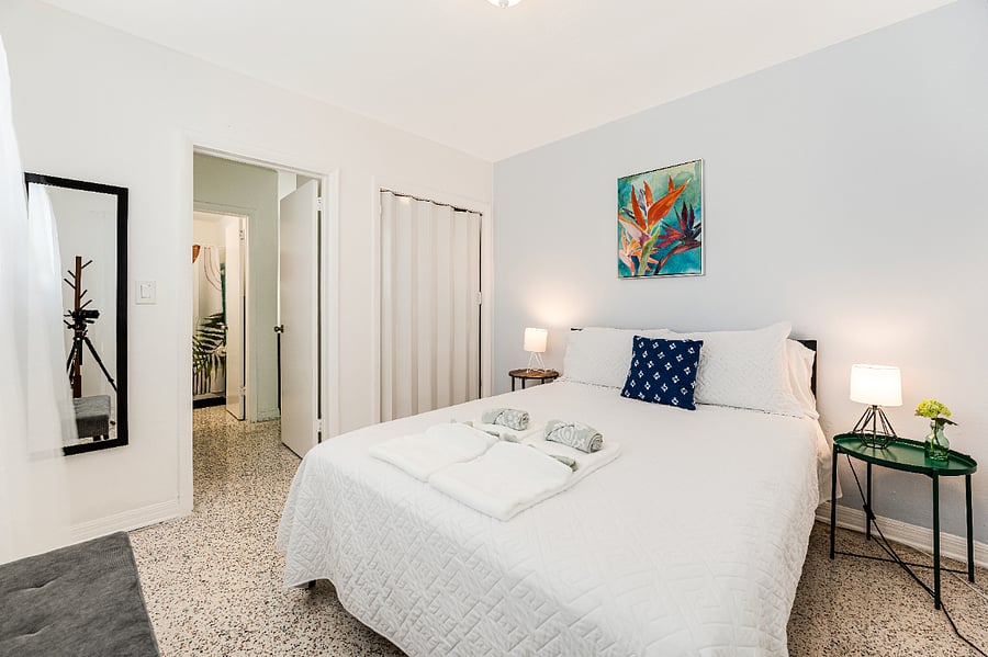 fully furnished bedroom with dresser, closet, and queen mattress.