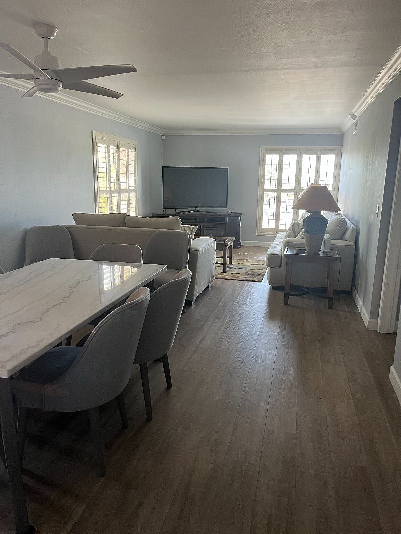 open concept living space with table for 6, comfortable sofas and large TV