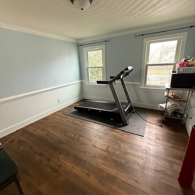 room attached to kitchen with treadmill, yoga mat, and light weights