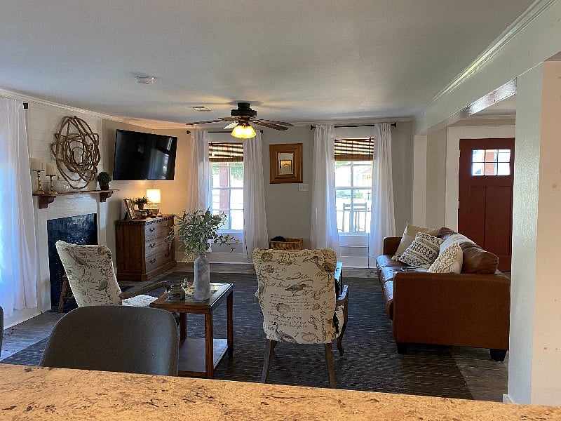 A large living room, with plenty of seating for and wall mounted Smart Roku TV for accessing Roku TV (Free) or any of the guests prefered streaming services.