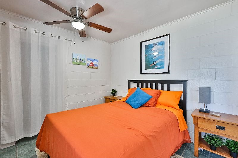 A relaxing double bedroom with a ceiling fan.
