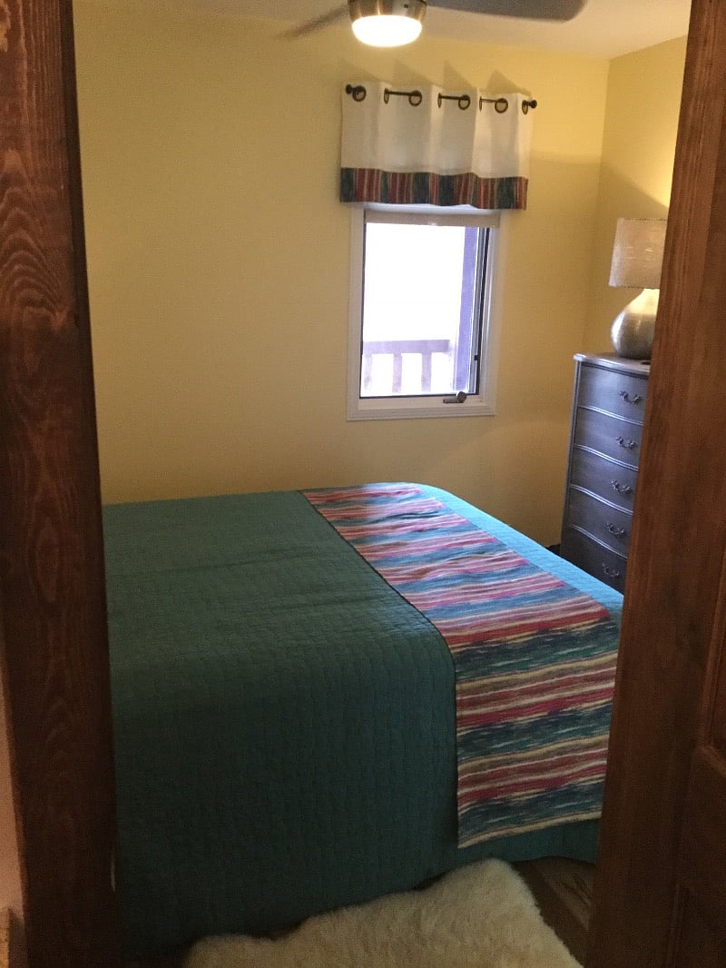5 drawer chest and 2 bedside tables. Sheepskin rugs on floor.