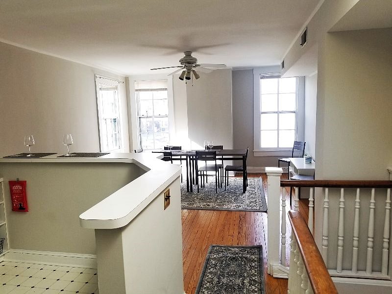 2nd Floor of the apartment with large 6 seat dining table and 2 stool seating at the breakfast bar looking into the kitchen - an abundance of natural lighting