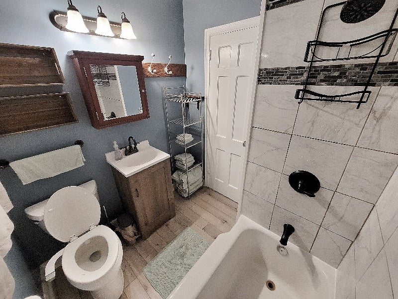 The bathroom is on the main level and includes a shower and bathtub, toilet with a bidet, as well as basic supplies like towels, shampoo, and conditioner. A hair dryer and iron are also available.