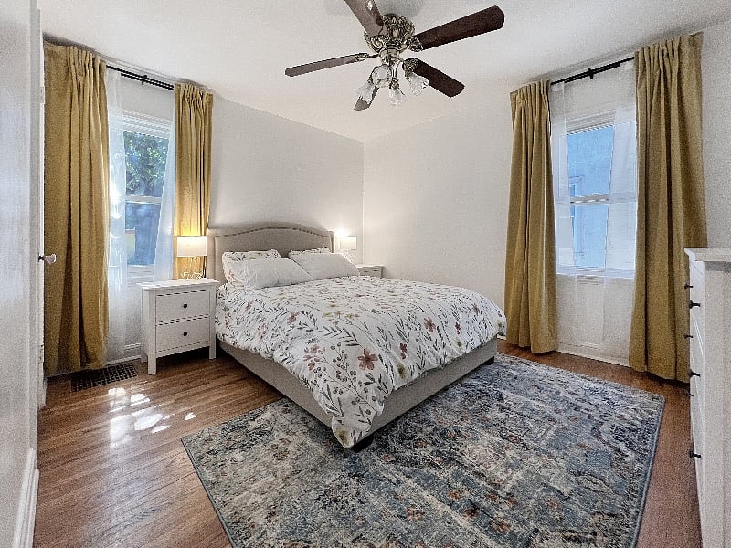 Bedroom #2, on the main level, includes plenty of natural light, a closet, and a dresser. Stay comfortable with the ceiling fan.