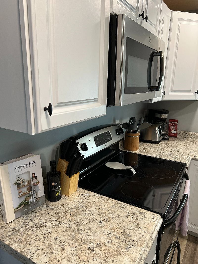 Kitchen is stocked with pots/pans, coffee pot, toaster, cooking utensils, dishware, silverware, knife set, spices, cookbook, and more.