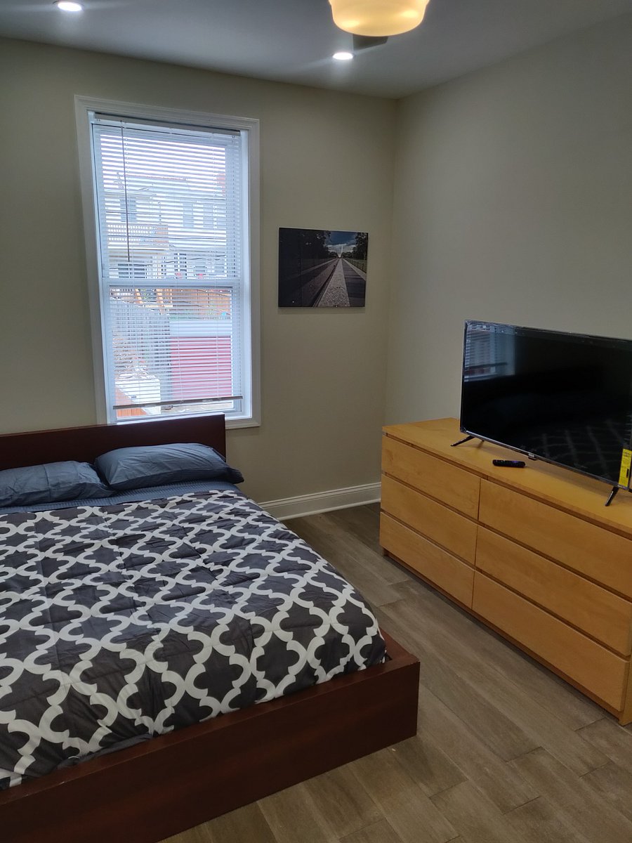 Medium-sized bedroom upstairs: full-sized bed, 40" TV, closet, and dresser.