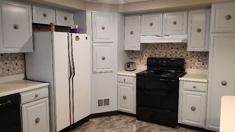Kitchen. Features refrigerator/freezer, electric stove/oven, steel sink, dishwasher, microwave, toaster, and coffee maker. Plenty of cabinet space. Cookware, plates/dishes, utensils, and trash can included.