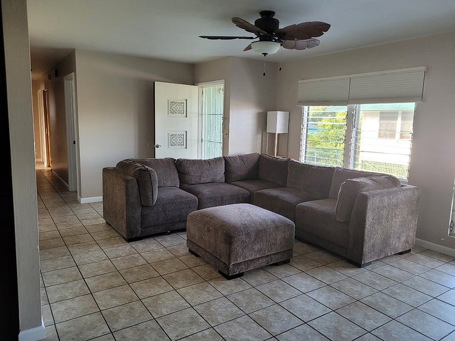 View of the front door and down the hall from the living room where the tv stands.