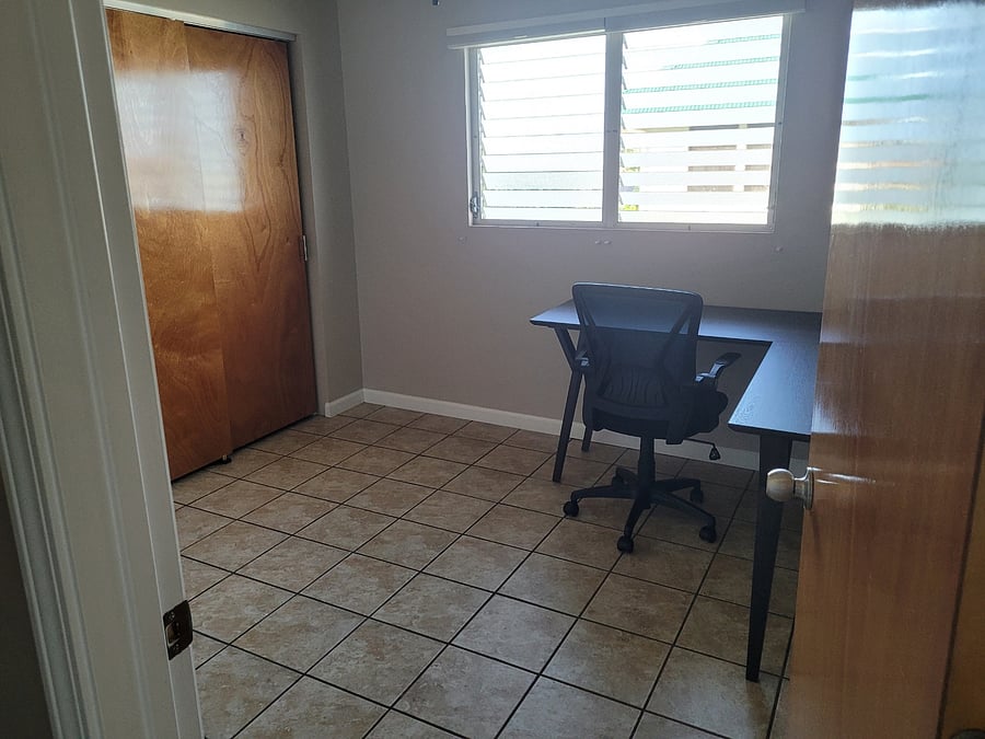Office space with L-shaped desk and chair.