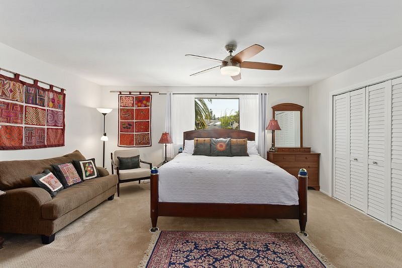 Master bedroom with seating area. Carpet has been replaced with plank flooring.