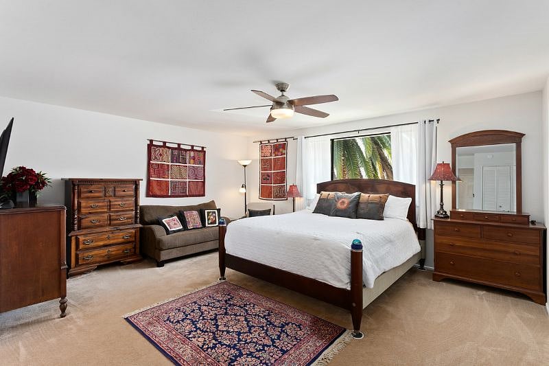 Master bedroom with seating area. Carpet has been replaced with plank flooring.