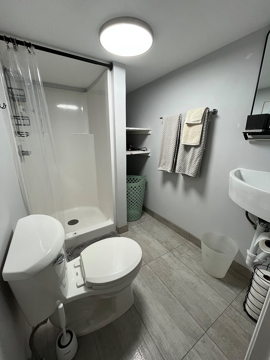 Bathroom with towels, hair dryer, hamper, cleaning supplies, Shark vacuum cleaner