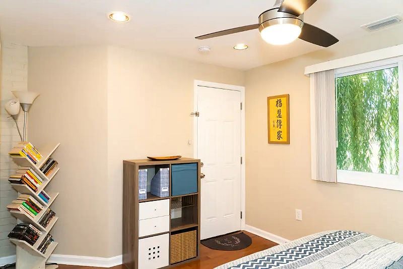 Stylish shelf serves as bedroom dresser. Tree shelf has some books and movies that can be perused during guests stay. Private back entrance conveniently leads out back to designated parking spot. 