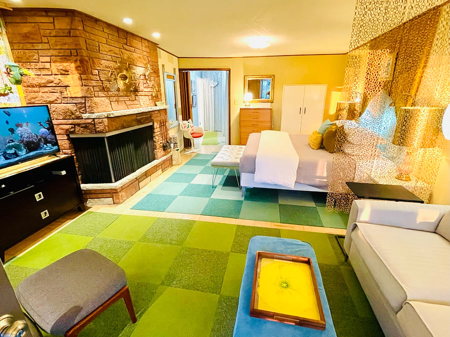 Seating and sleeping centered on wrap-around wood-burning fireplace.