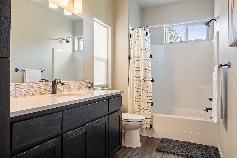 Downstairs bathroom with bathtub and ample storage.
