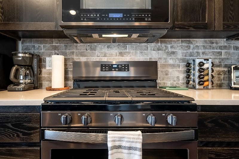Kitchen with gas range, fridge, freezer, dishwasher & microwave.