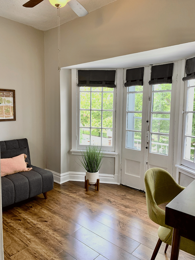 Twin sofa chair converts to bed, French doors open to small balcony.