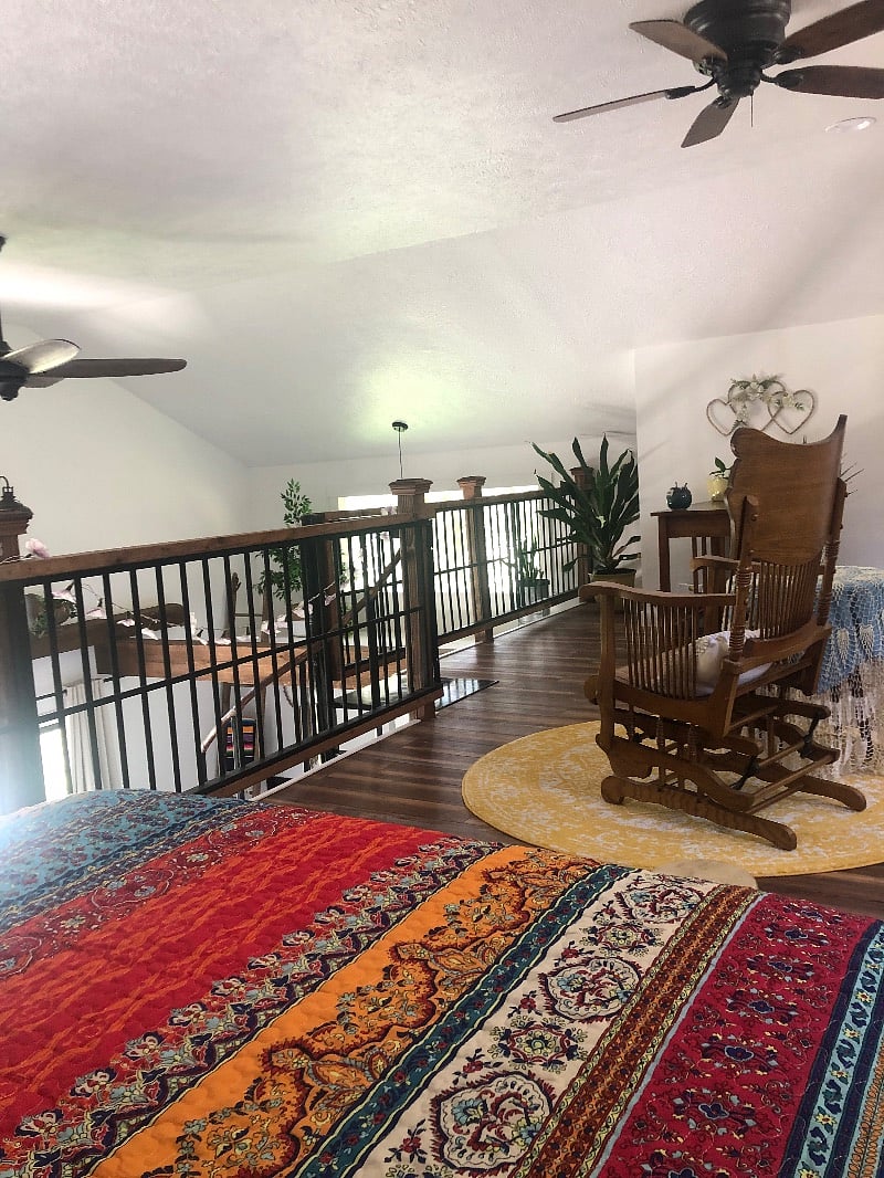Loft bedroom with desk and sitting are.