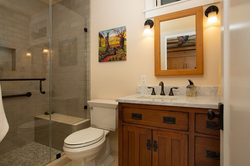 Spacious, beautifully tiled bathroom with large storage cupboard.