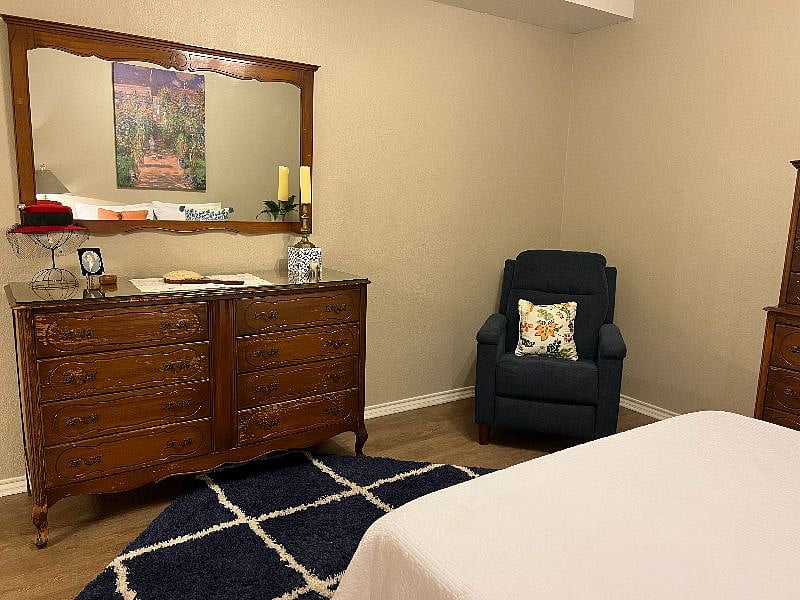 Bedroom with dresser and recliner.